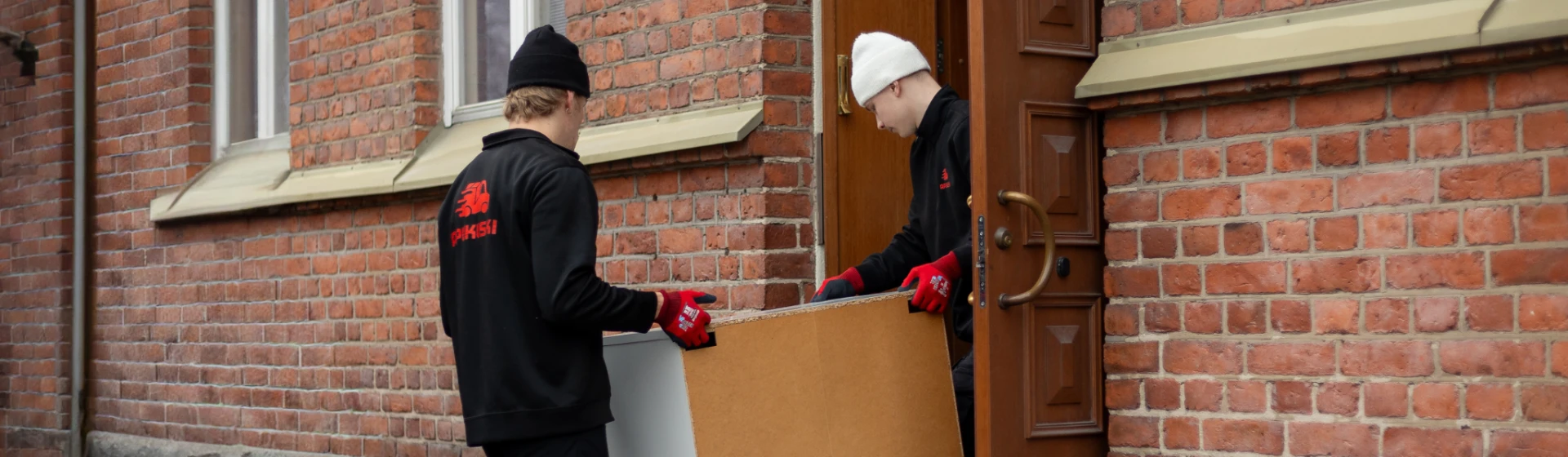 Apukuskin kuskit kantavat huonekalua sisään